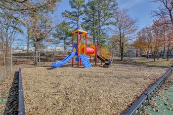 a playground with a blue and yellow swing set and a red and yellow slide