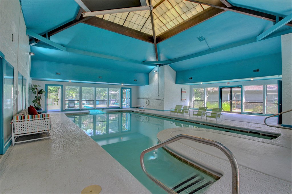 a large indoor swimming pool with a large windowed ceiling