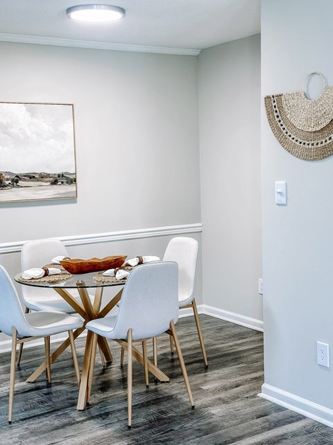 A dining room with a white table and chairs.