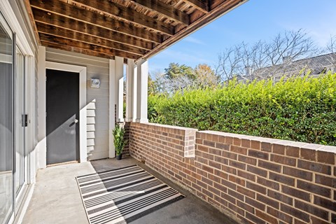 A house entrance with a striped rug on the ground.