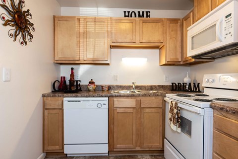 A kitchen with wooden cabinets and white appliances.
