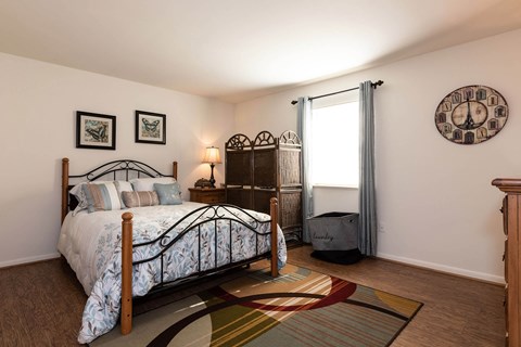 A bedroom with a large bed and a clock on the wall.