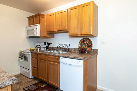 A kitchen with wooden cabinets and white appliances.