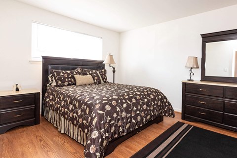A bedroom with a large bed and a mirror on the wall.