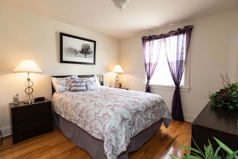 A bedroom with a large bed and a painting on the wall.