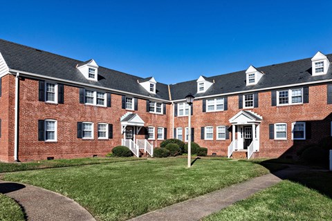 A red brick building with white trim and black shutters.