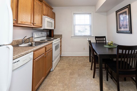 A kitchen with a table and chairs.