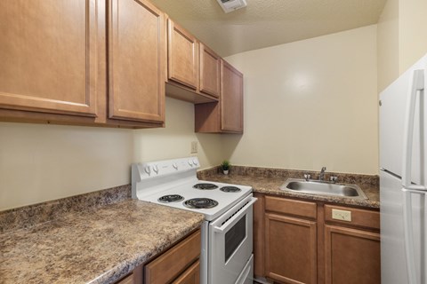 A kitchen with a white stove top oven and a white refrigerator.