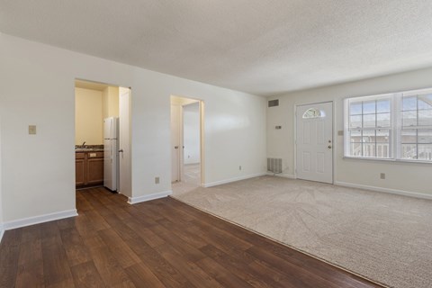 A spacious room with wooden floors and white walls.