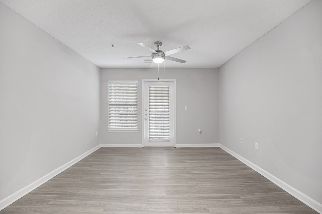 an empty living room with white walls and a ceiling fan at Midtown Crossing in Raleigh, NC 27609