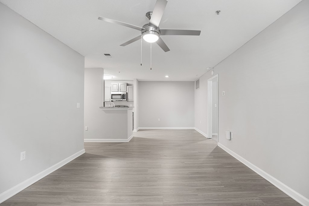 an empty living room with white walls and a ceiling fan at Midtown Crossing in Raleigh, North Carolina