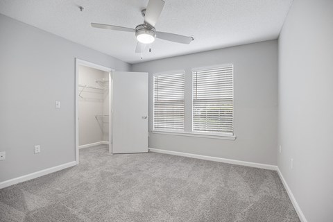 an empty bedroom with a ceiling fan and a bathroom at Midtown Crossing in NC 27609