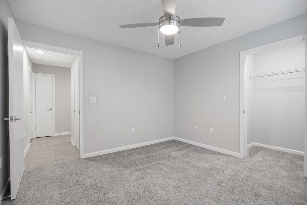 an empty bedroom with a ceiling fan and a door to a closet at Midtown Crossing in Raleigh, North Carolina 27609