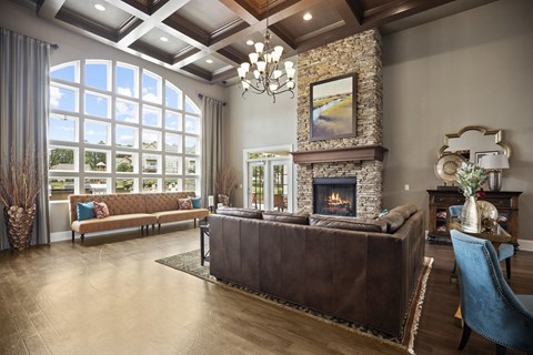 A living room with a brown leather couch and a stone fireplace.