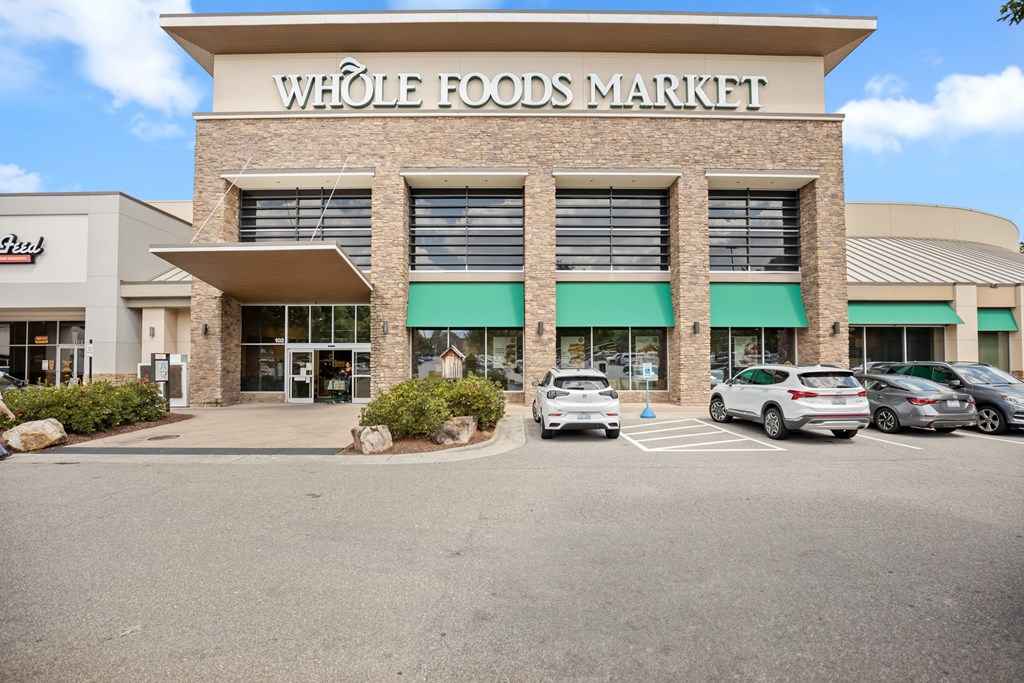 A Whole Foods Market store with cars parked in front.