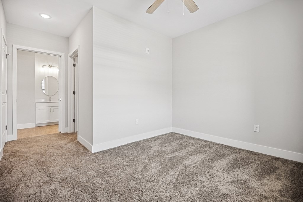 an empty living room with carpet and a ceiling fanat Centro at Pine Nash, Wilson