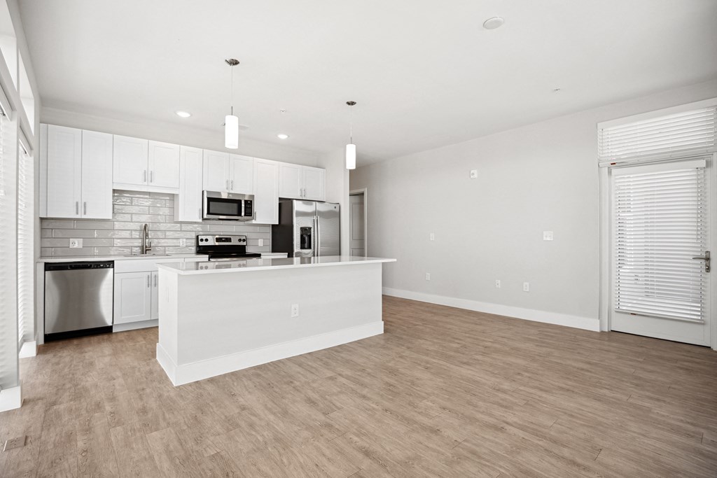 an open kitchen and living room with a large island and white cabinetsat Centro at Pine Nash, North Carolina
