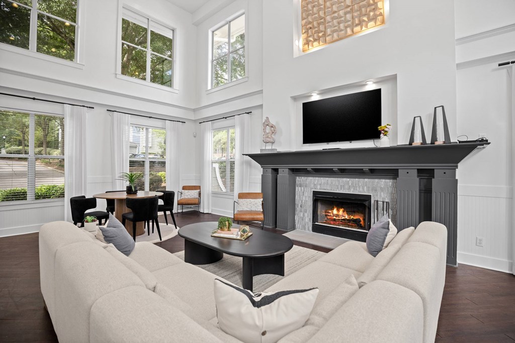 A living room with a fireplace and a television on the wall.