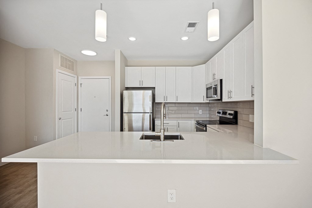an empty kitchen with a white counter top and a refrigeratorat Centro at Pine Nash, Wilson, North Carolina