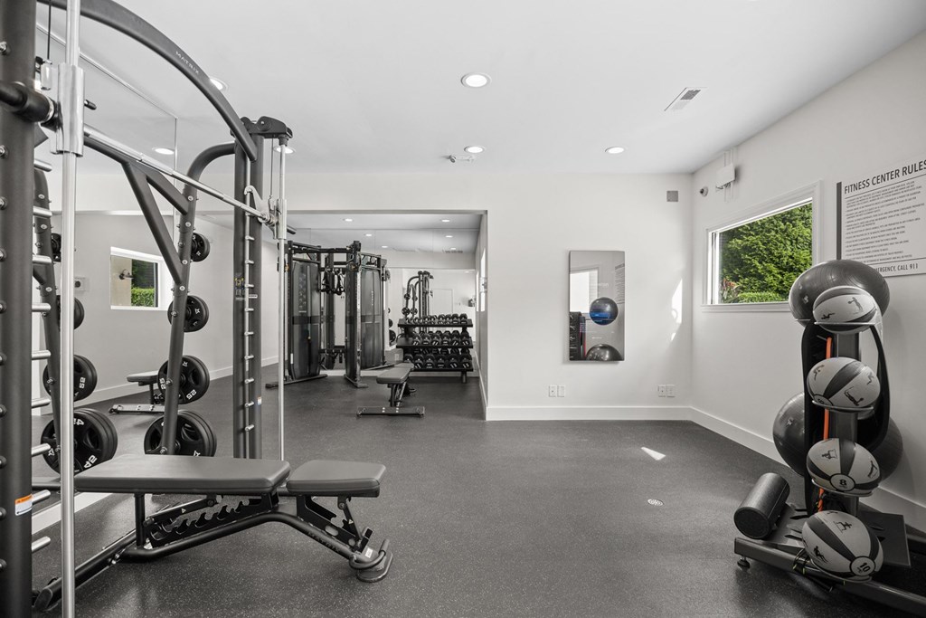 A gym with a variety of equipment including weights and a bench.