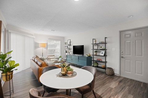 A living room with a white table and brown chairs.