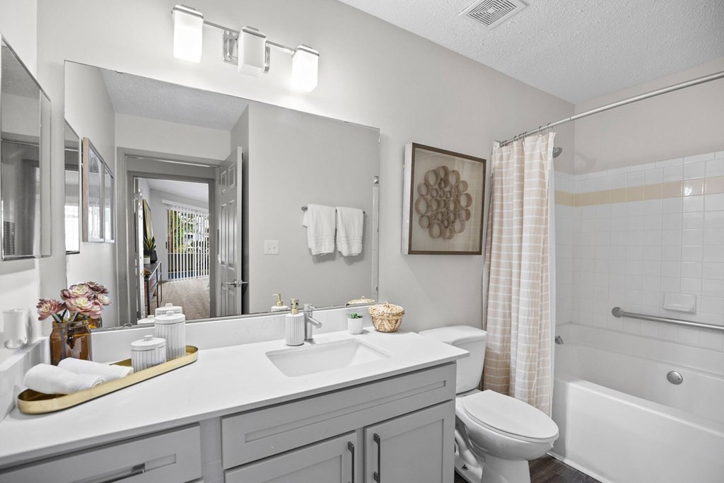 A bathroom with a white toilet, sink, and bathtub.