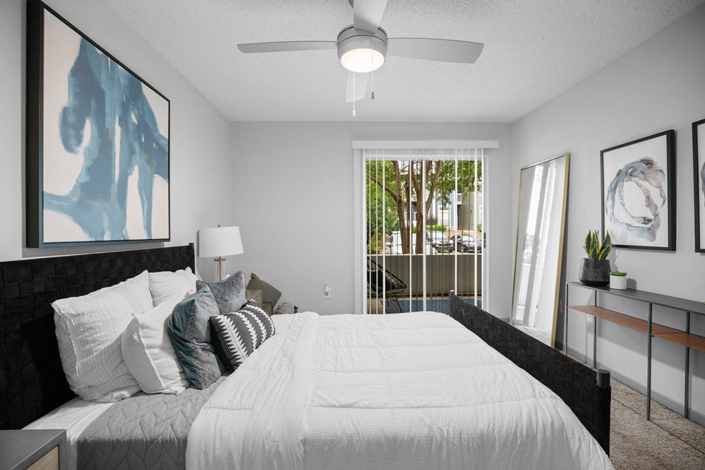 A bedroom with a large bed and a ceiling fan.