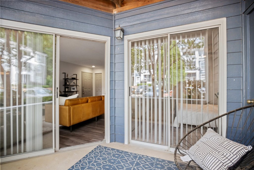 A living room with a yellow couch and a blue and white patterned rug.