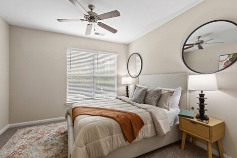 A bedroom with a large bed and a ceiling fan.