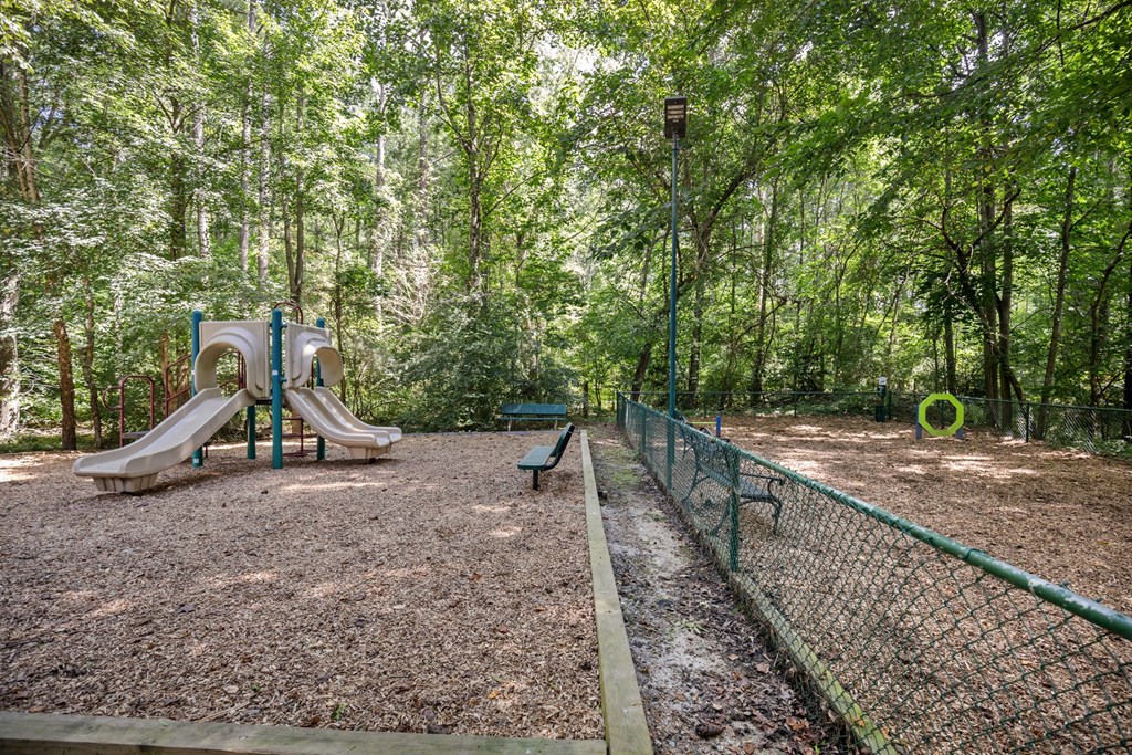 A playground with a slide and a fence.