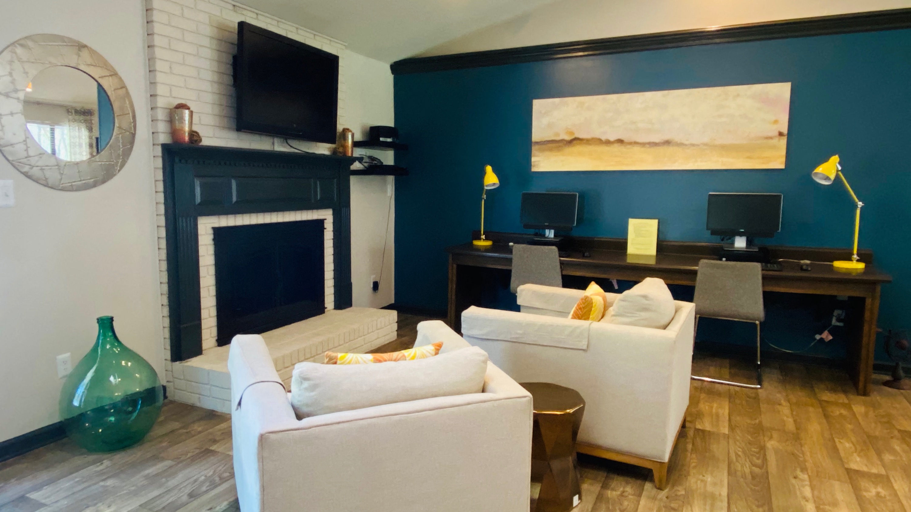 A living room with a fireplace and a painting on the wall.