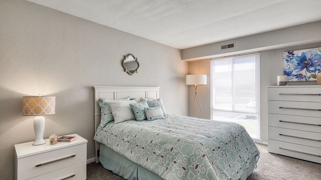 a bedroom with a bed and a window  at Bayville Apartments, Virginia Beach, Virginia