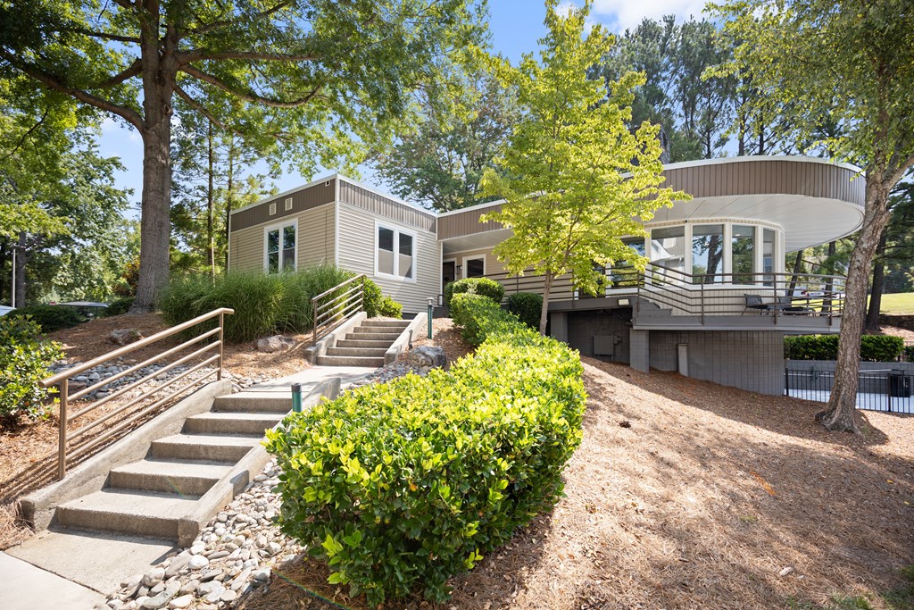 a house with stairs and a yard with trees