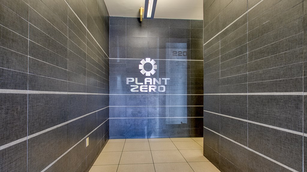 the entrance to a plant zero bathroom with a large sign on the side of it