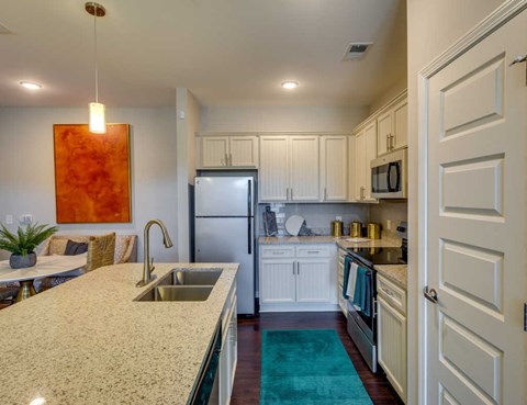 A kitchen with a sink and a refrigerator.