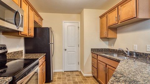 a kitchen with granite counter tops and wooden cabinets