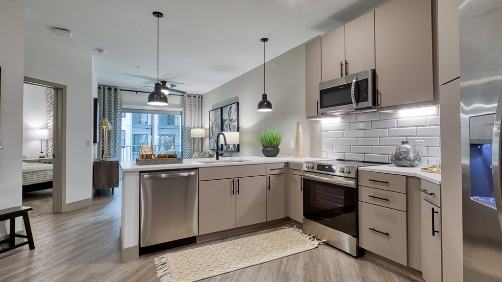 an open kitchen with stainless steel appliances and white counter tops an open kitchen with stainless steel appliances and white counter tops at Aura Stonebridge, Richmond, VA