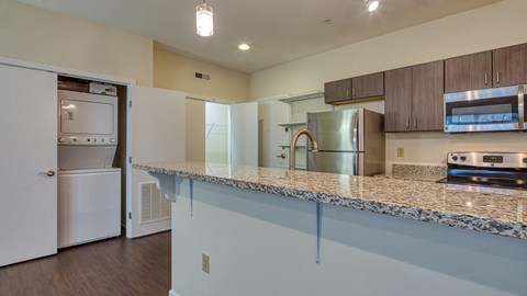 a kitchen with a granite counter top and a stainless steel refrigerator