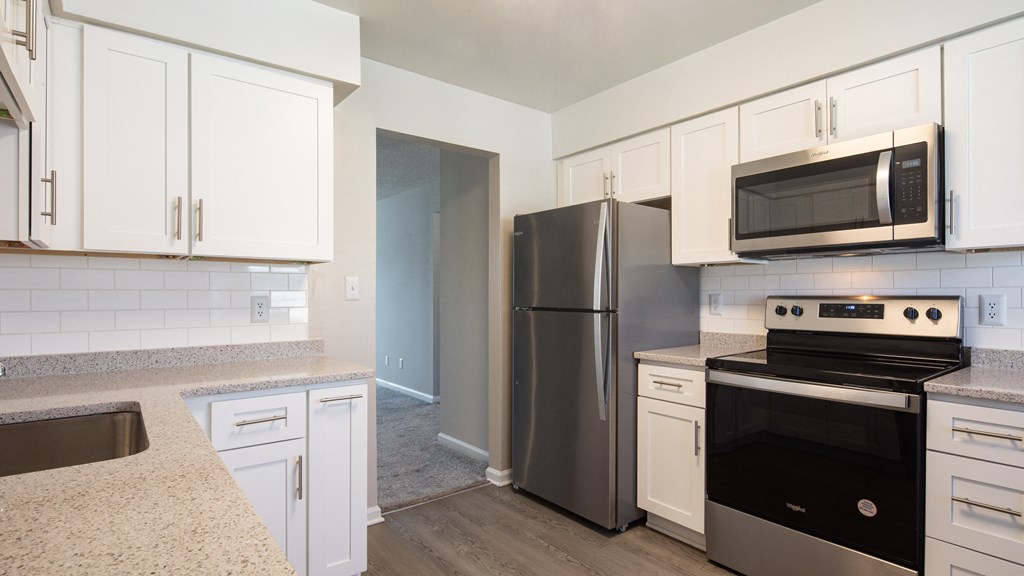a kitchen with white cabinets and stainless steel appliances