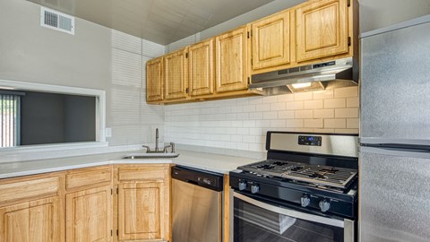 a kitchen with wood cabinets and a stove and a sink