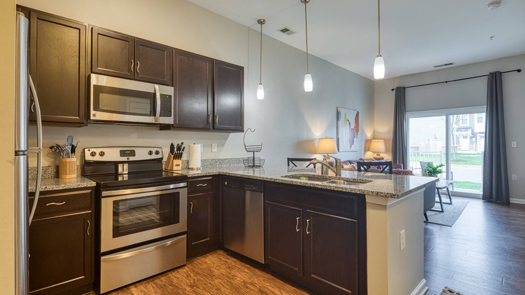 an open kitchen with stainless steel appliances and granite counter tops