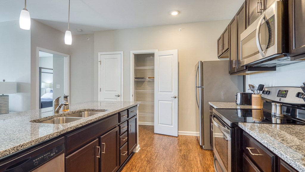 a kitchen with granite counter tops and a stainless steel refrigerator