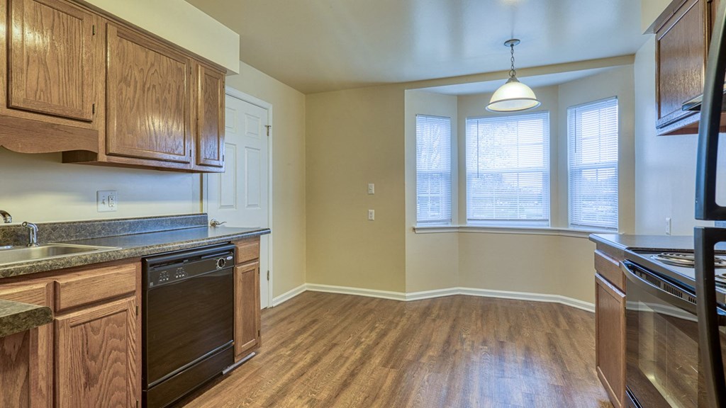 A kitchen with wooden cabinets and a black oven.
