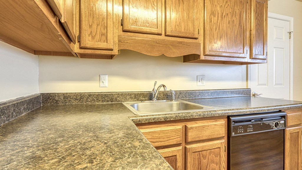 A kitchen with wooden cabinets and a granite countertop.