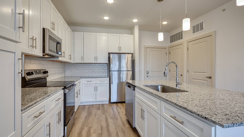 a kitchen with marble counter tops and white cabinets a kitchen with marble counter tops and white cabinets at The Walker Virginia Center, Glen Allen, VA