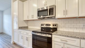 A kitchen with a stove top oven and microwave above it at The Walker Virginia Center, Glen Allen, Virginia, 23059