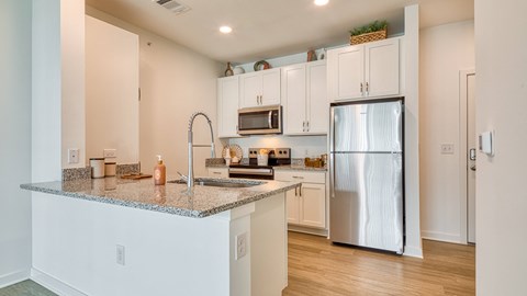 a kitchen with a granite counter top and a stainless steel refrigerator at Allure at Edinburgh, Virginia, 23322