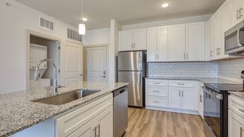 A kitchen with white cabinets and a granite countertop at The Walker Virginia Center, Glen Allen, 23059