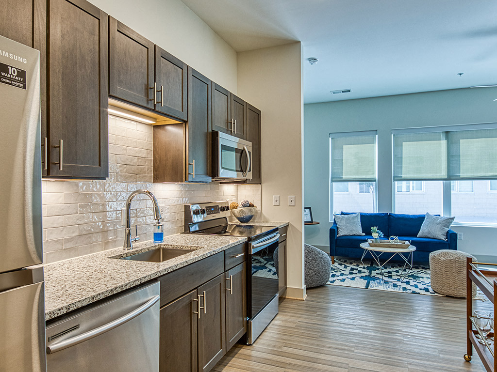 A modern kitchen with dark wood cabinets and stainless steel appliances.