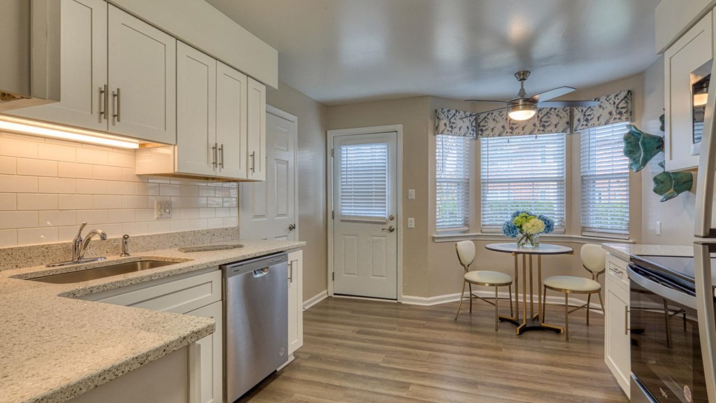 A kitchen with a table and chairs by a window.